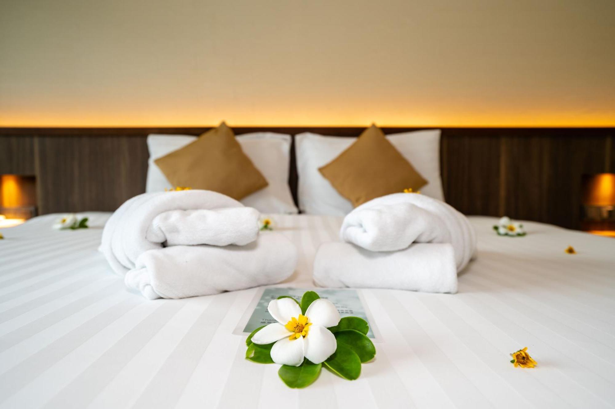 Le Resort And Villas Rawai Exterior foto A bed with towels and flowers